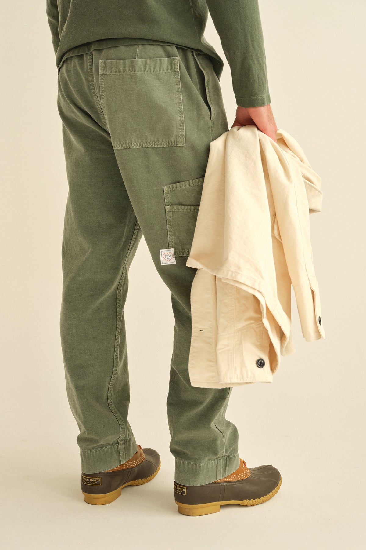 Worker pants in olive-green with front cargo pocket, elastic waistband, and drawstring ties