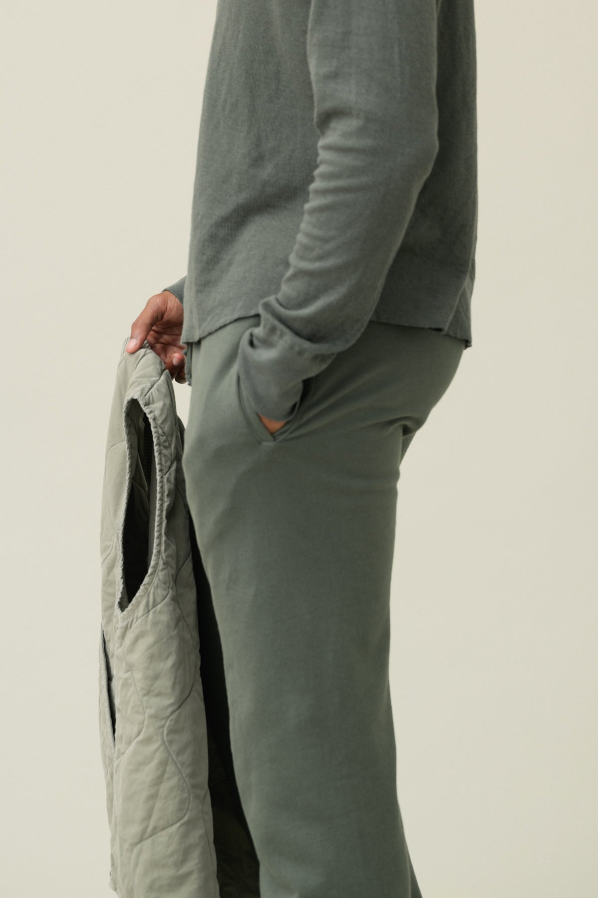 Olive green fleece sweatpants with relaxed ankle and visible pocket opening