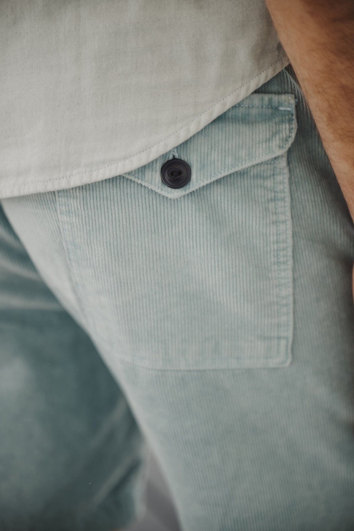 Corduroy easy shorts in light blue, close-up of button and front pocket.