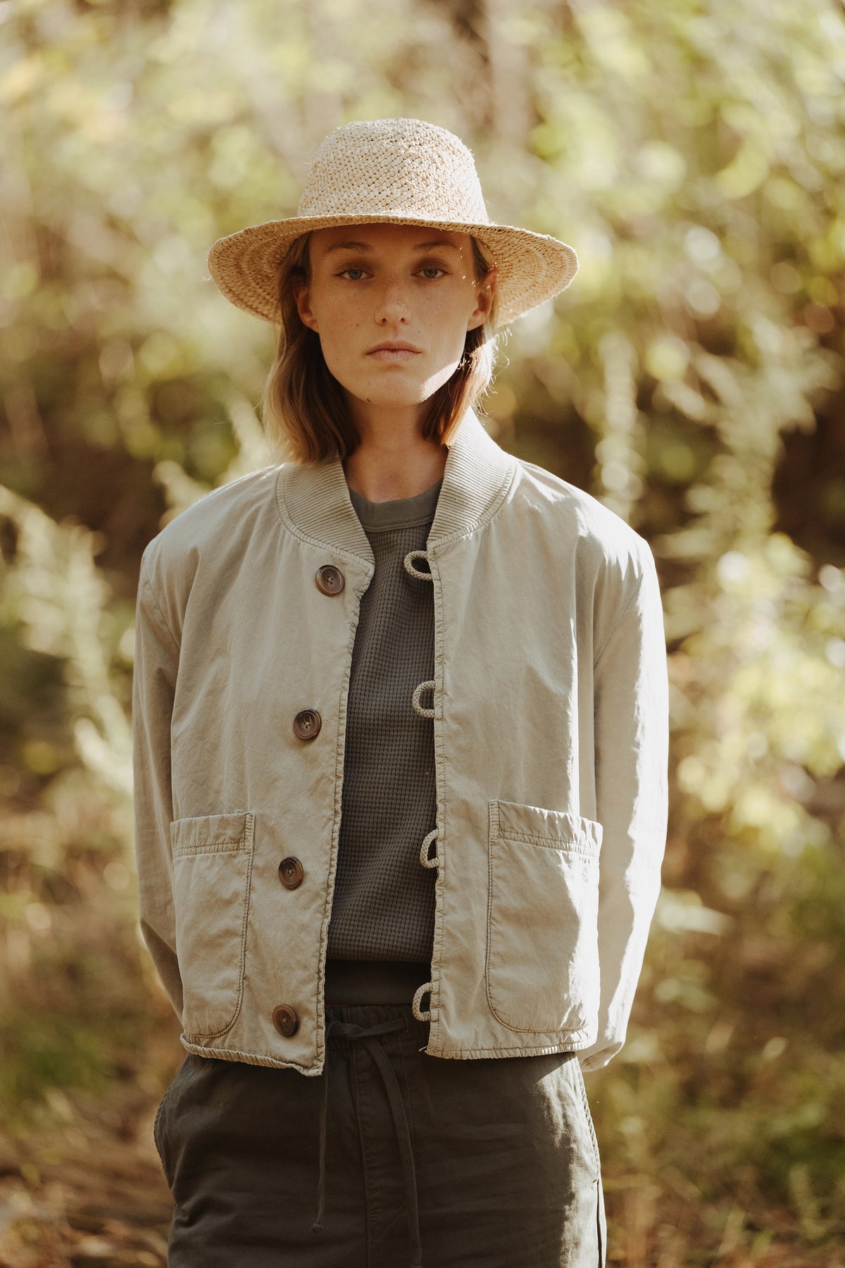 Olive surplus jacket with button front, stand collar, and flap chest pockets.