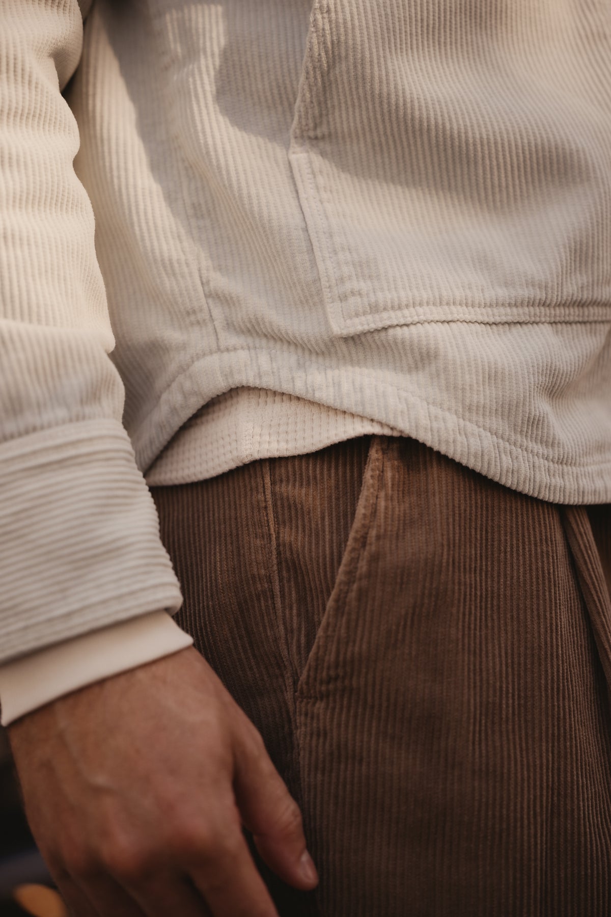 Silver corduroy trucker jacket close-up showing a sleeve cuff and hem.