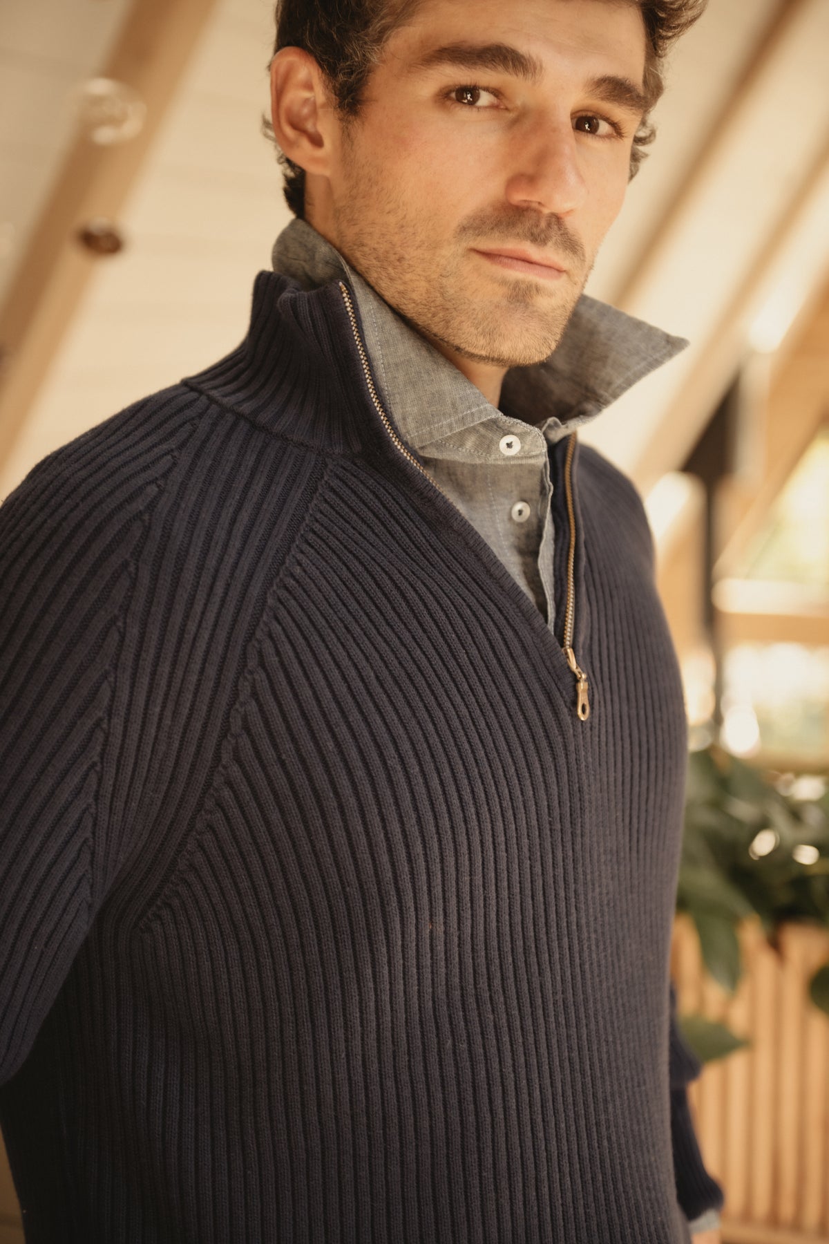Navy cotton 1/4-zip sweater close-up with ribbed texture and quarter zipper
