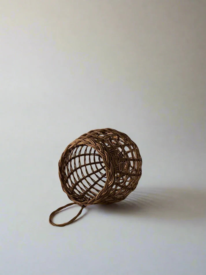 Sweet onion basket with open weave net and long loop handle, brown tone.