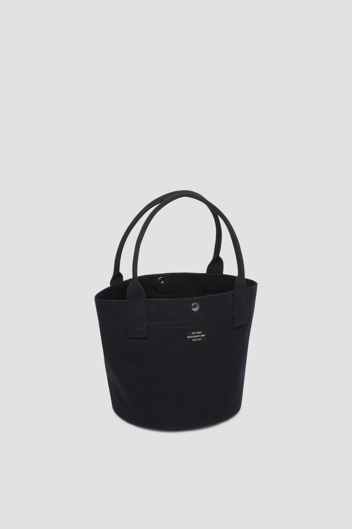 Round canvas tote bag in black with short handles and front pocket