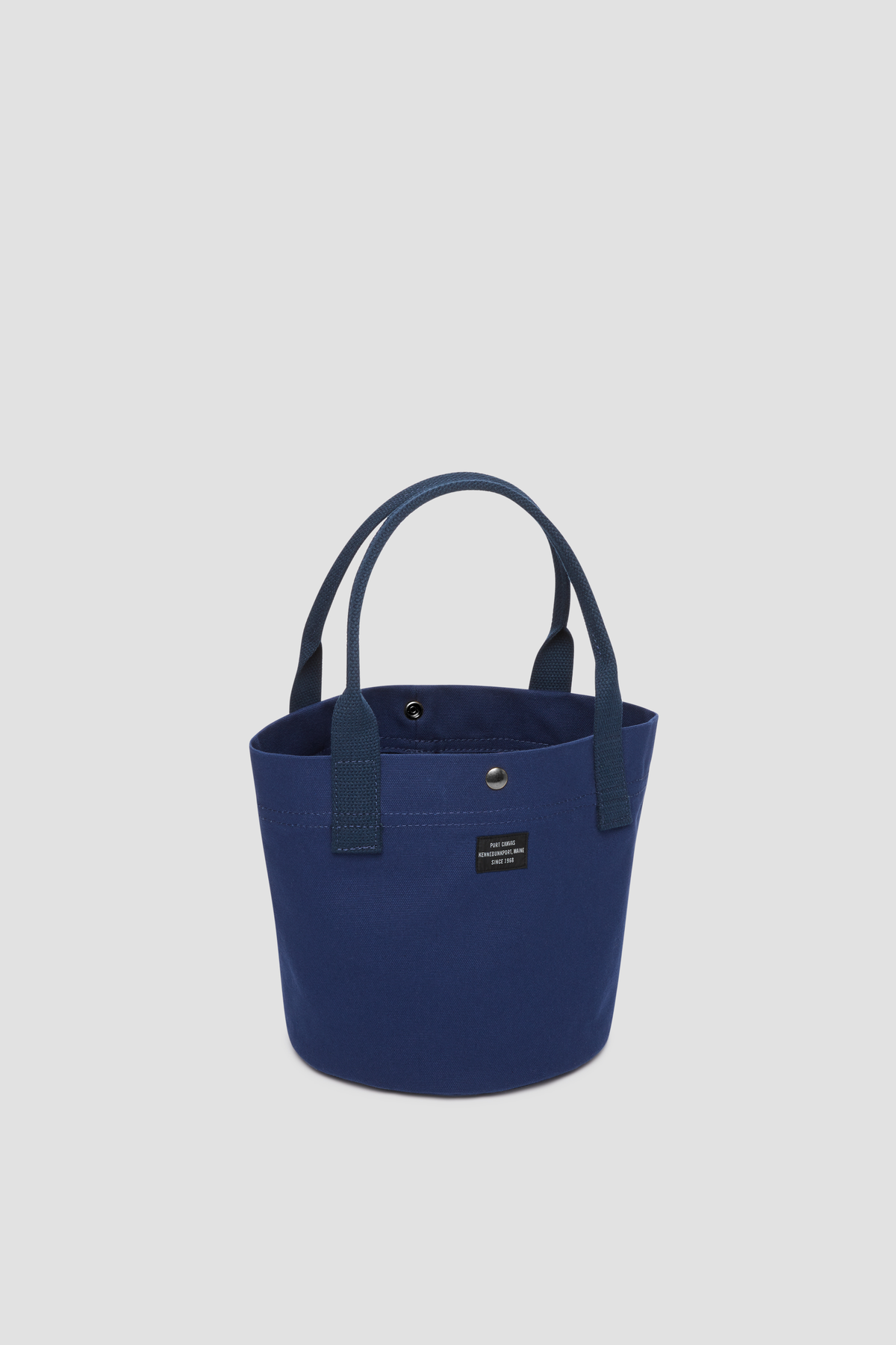 Round canvas tote bag in navy blue with short handles and front pocket
