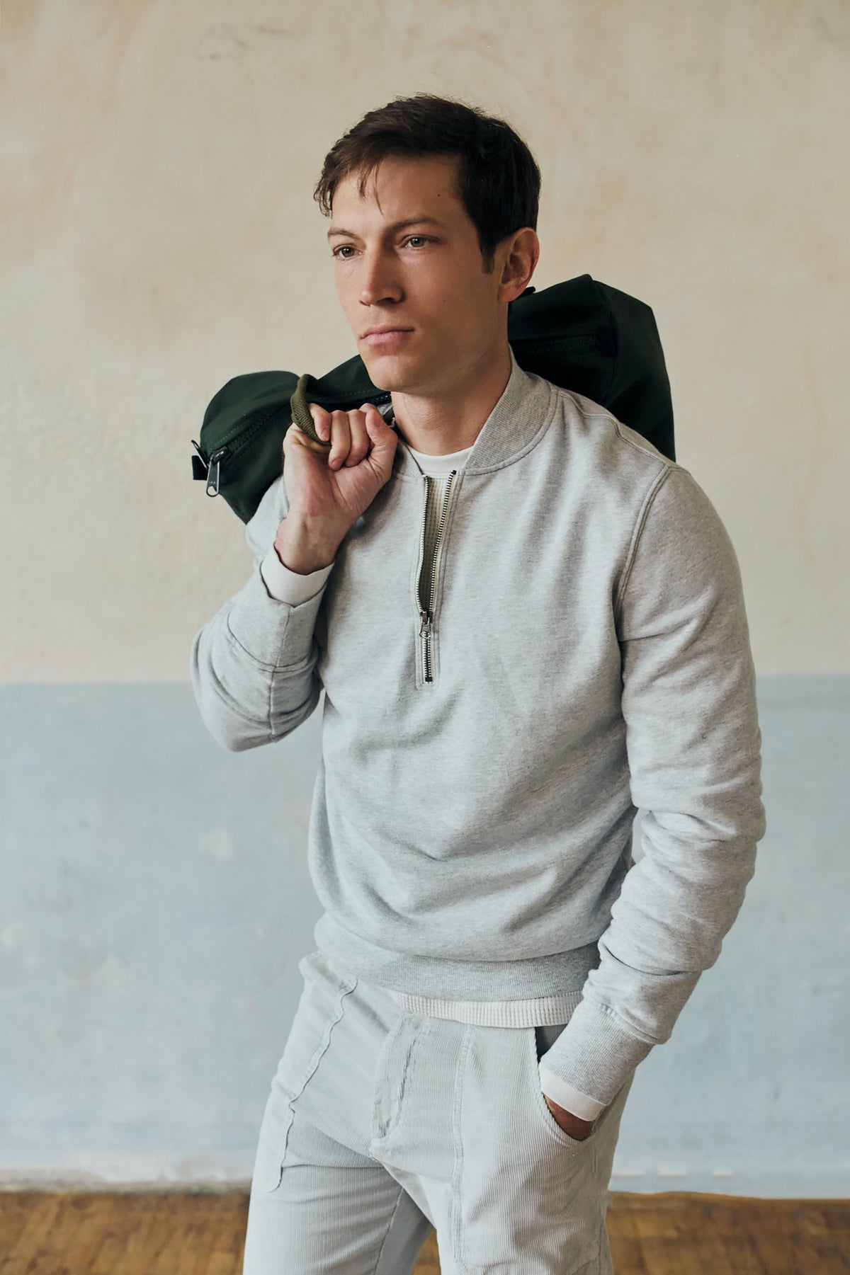 Heather grey quarter-zip pullover on model, half-zip front with ribbed cuffs