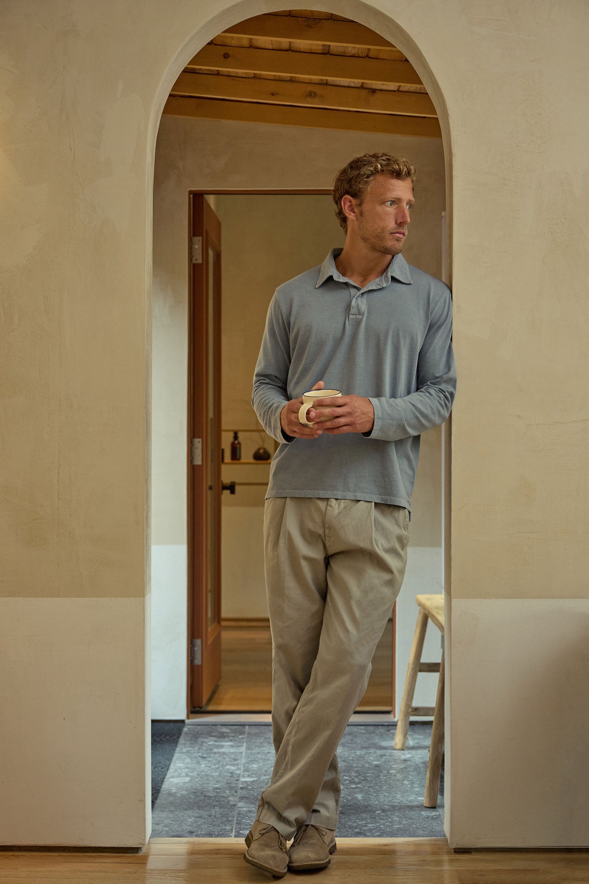 Light blue long-sleeve polo shirt worn by model with collar and button placket