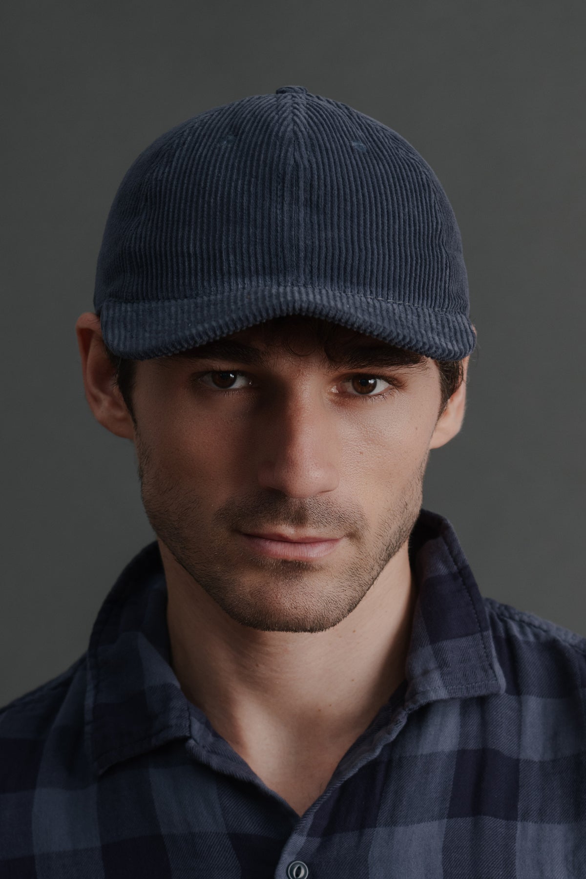 Navy wide wale corduroy baseball cap on model, front view with curved brim