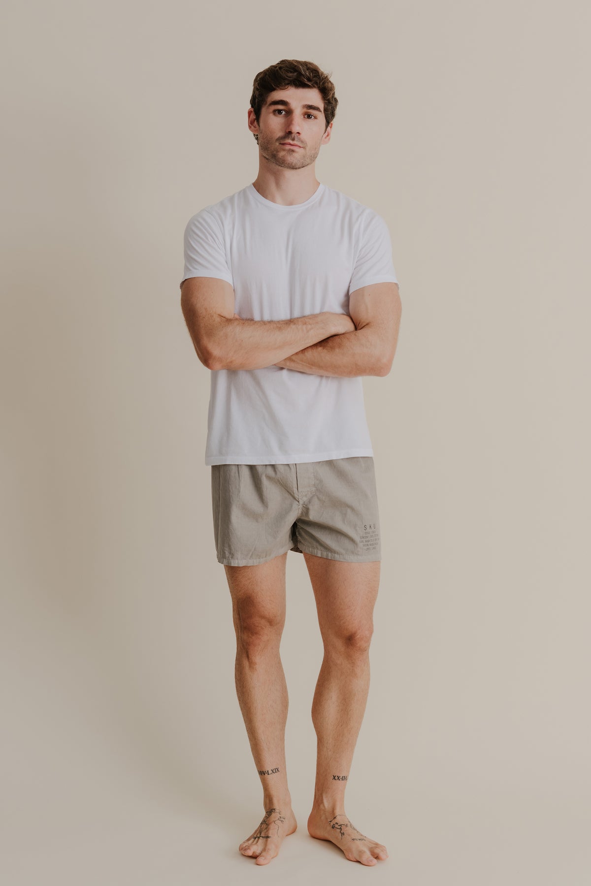 Khaki distressed-dye boxers on model, elastic waistband and short length