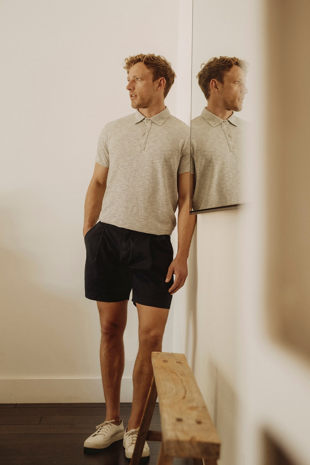 Mens short-sleeve polo shirt in light heather worn with dark shorts